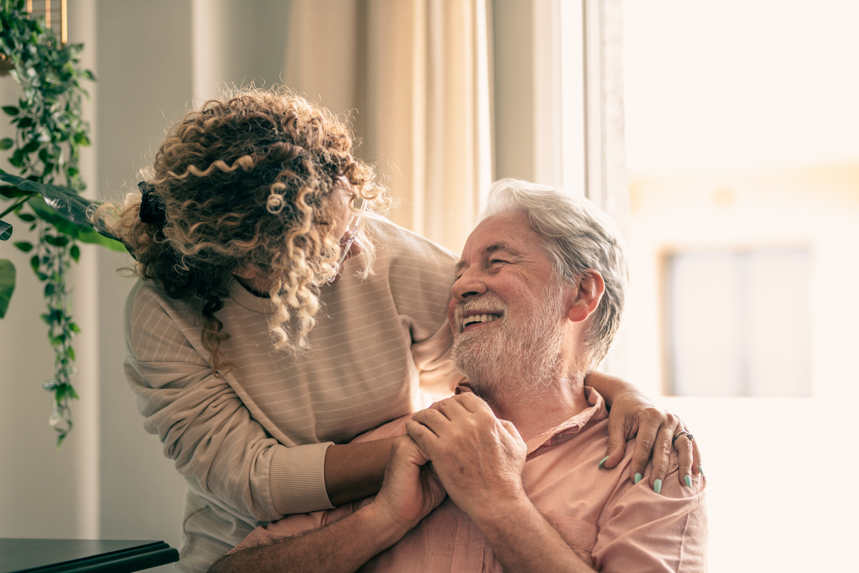portrait of bearded senior man looking at his middle aged daughter, spending time together at home