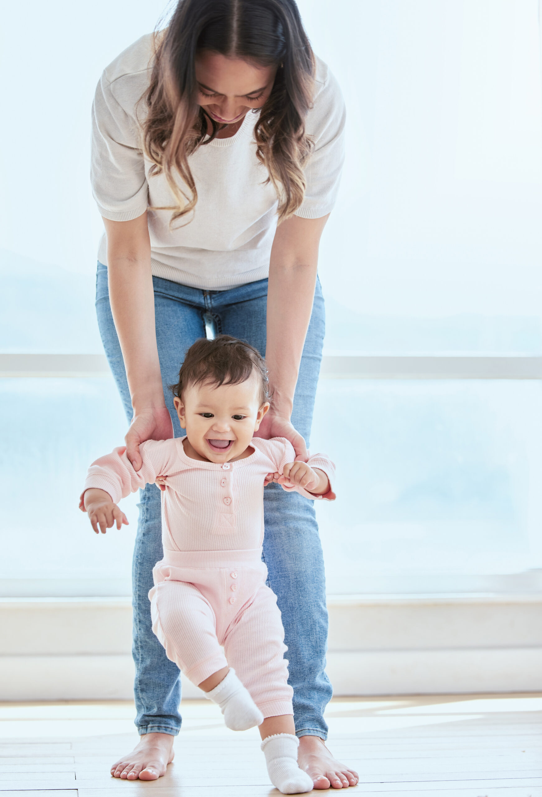 shot of a sweet baby girl bonding with her while learning to take her first steps at home